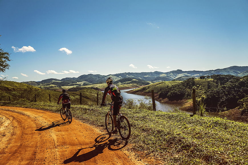 Mountain Bikers on Dirt Road Overlooking River Valley