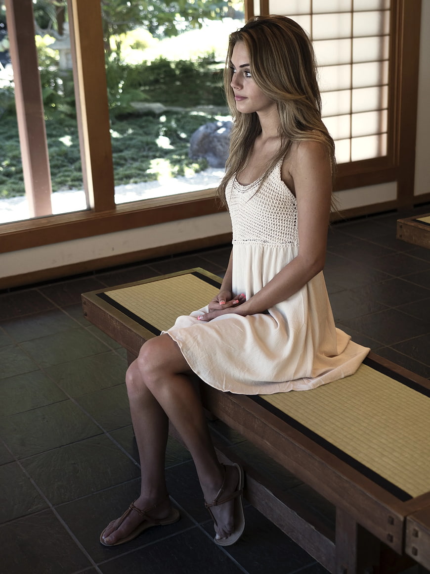 Woman in White Dress Sitting on Wooden Bench