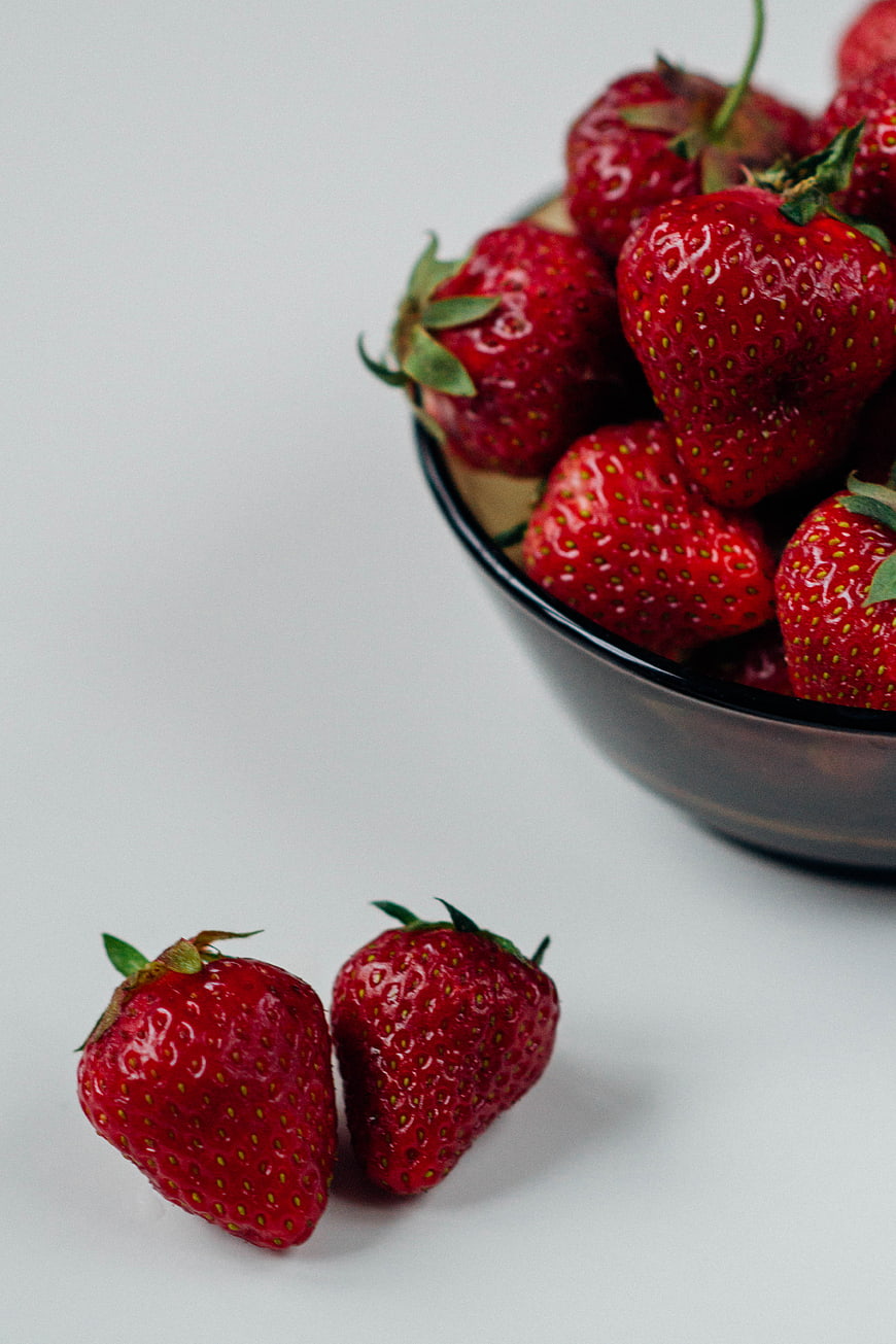 Fresh Red Strawberries in Black Bowl on White Background
