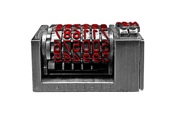 Vintage metal numbering machine with red digits on white background