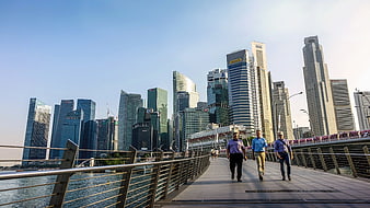 Three Men Walking on Bridge with Singapore Skyline Background