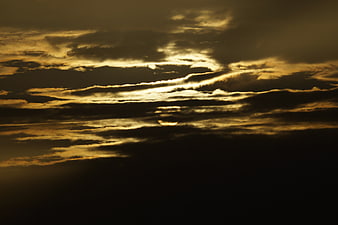 Dramatic golden sunset clouds with sun breaking through