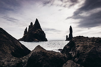 Dramatic Sea Stacks and Rocky Coastline Under Cloudy Sky