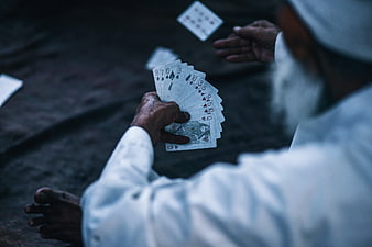 Man Playing Cards On Ground In India