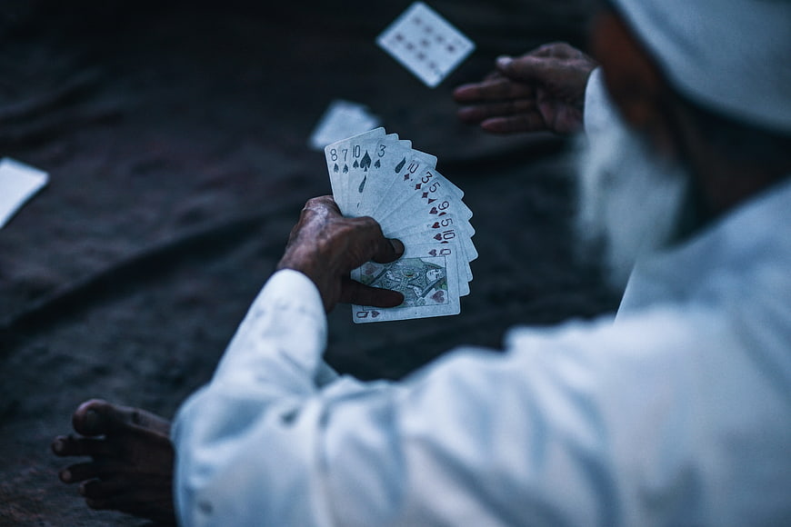 Man Playing Cards On Ground In India