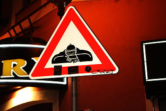 Humorous street sign with cartoon burglar warning symbol