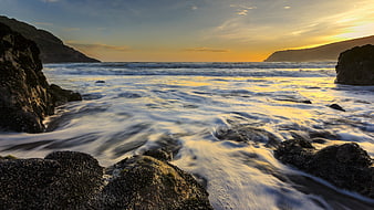 Golden Sunset Over Rocky Coastal Ocean Waves