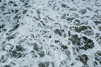 Aerial View of White Sea Foam on Dark Ocean Water