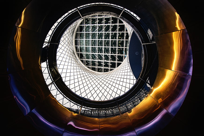 Abstract architectural view of a modern glass atrium with golden reflections