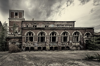 Abandoned brick factory building with graffiti and broken windows