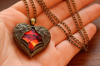 Vintage Winged Heart Necklace with Red Gemstone in Hand