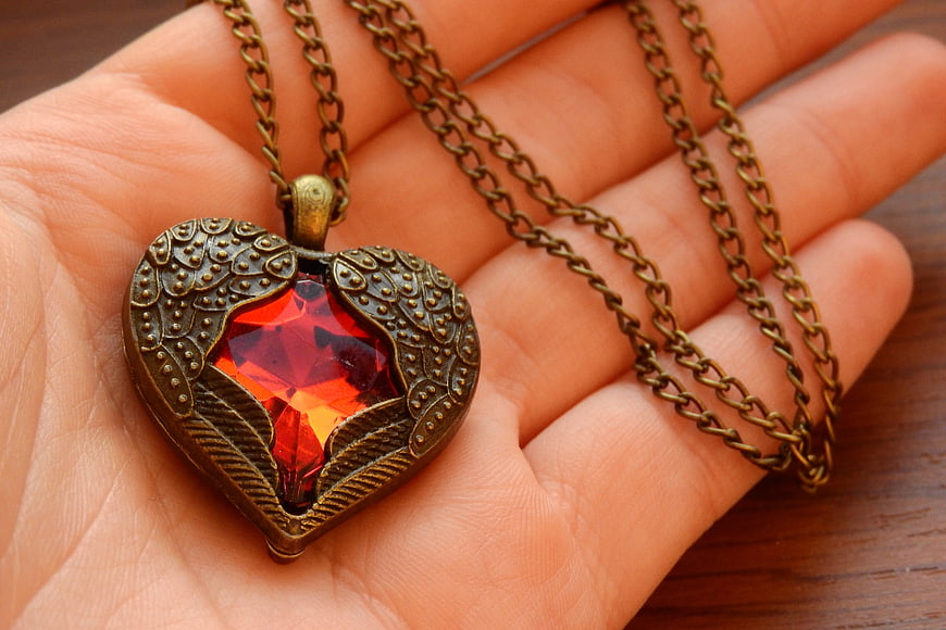 Vintage Winged Heart Necklace with Red Gemstone in Hand