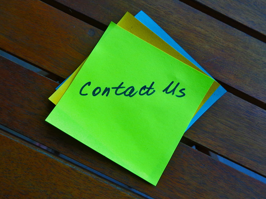 Contact Us Sticky Note on Wooden Table