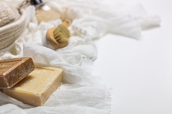 Natural Soap Bars and Wooden Brush on White Linen