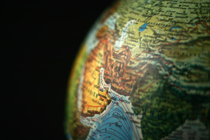 Close-up of a globe map showing Iran, Afghanistan, and Central Asia