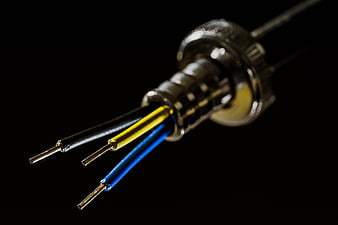 Macro shot of electrical cable with exposed wires on black background