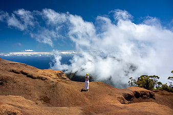 Woman Hiking on Mountain Peak Above Clouds