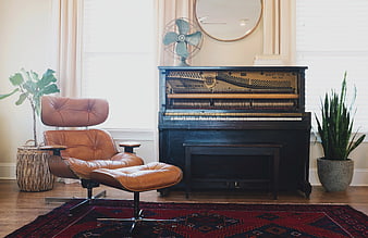 Vintage upright piano and leather lounge chair in cozy living room