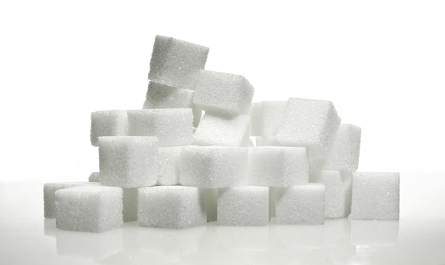 Stack of white sugar cubes on a white background