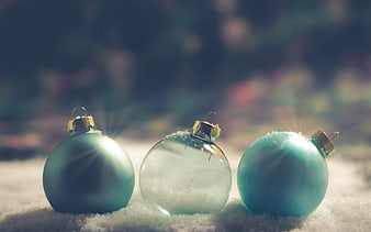 Three Blue Christmas Ornaments in Snow with Sun Flares