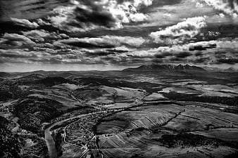 Dramatic black and white aerial landscape with mountains and clouds