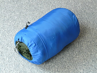 Blue Packed Sleeping Bag On Gray Concrete Surface