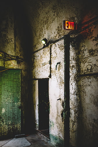 Glowing red exit sign in abandoned dilapidated building