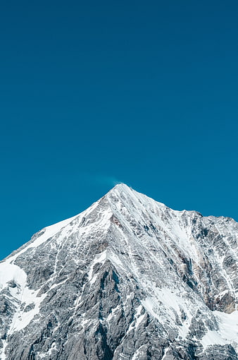 Snow-Capped Mountain Peak Against Clear Blue Sky