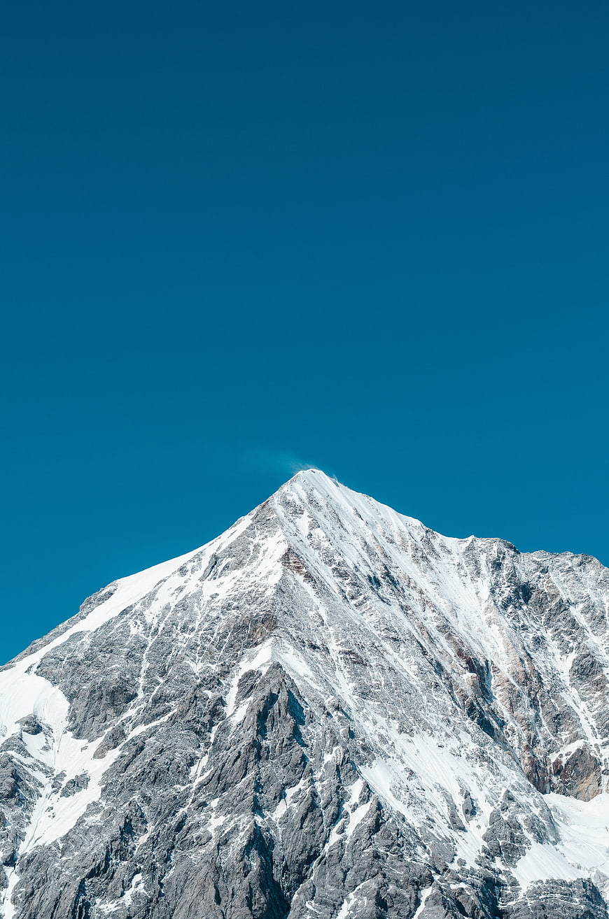 Snow-Capped Mountain Peak Against Clear Blue Sky