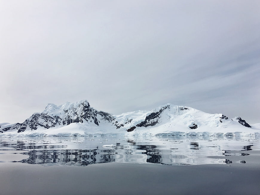 Snow-Capped Mountains Reflected in Calm Antarctic Waters