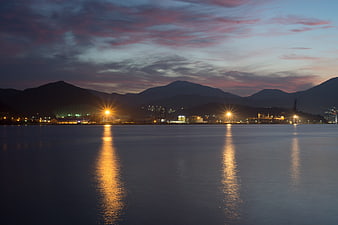 Dusk Landscape With Mountain Silhouettes And Water Reflections