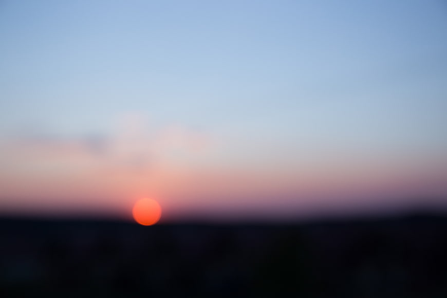 Blurred Sunset Sky with Orange Sun and Blue Gradient Background