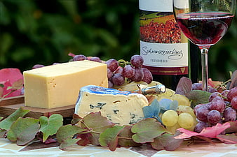 Gourmet cheese platter with red wine and grapes