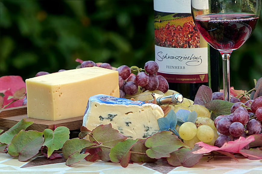 Gourmet cheese platter with red wine and grapes