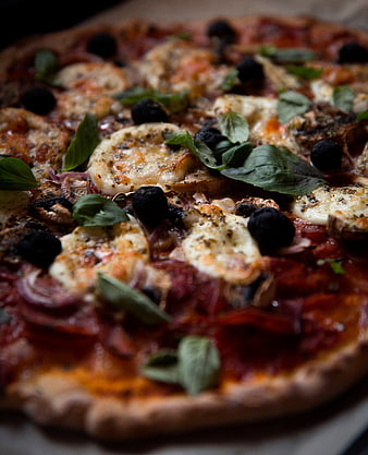 Close-up of homemade pizza with mozzarella, basil, and olives