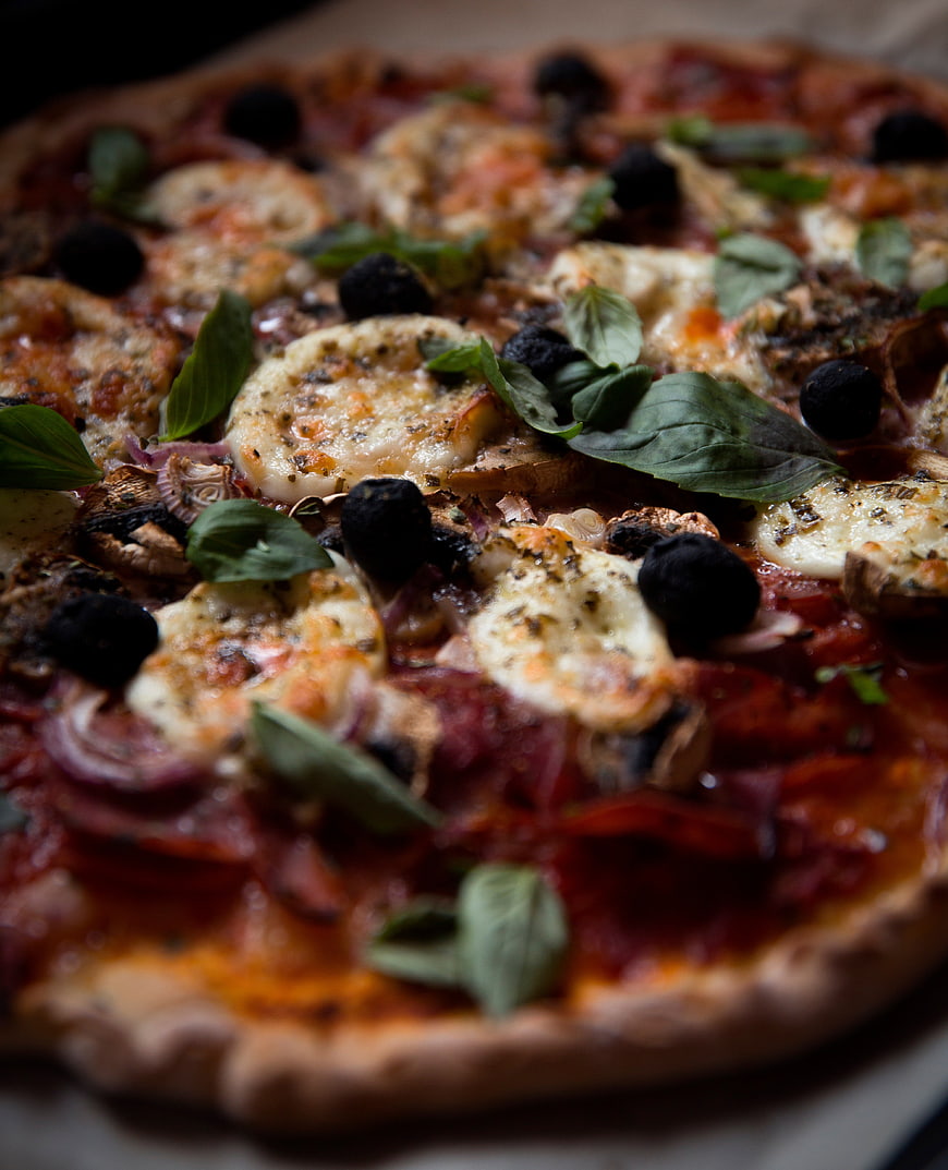 Close-up of homemade pizza with mozzarella, basil, and olives
