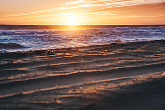Golden Sunset Over Ocean Waves and Sandy Beach Shore