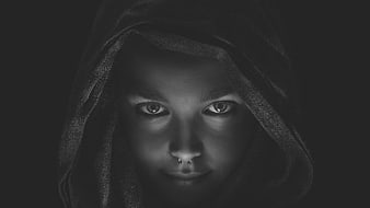 Mysterious woman in hooded cloak with nose piercing
