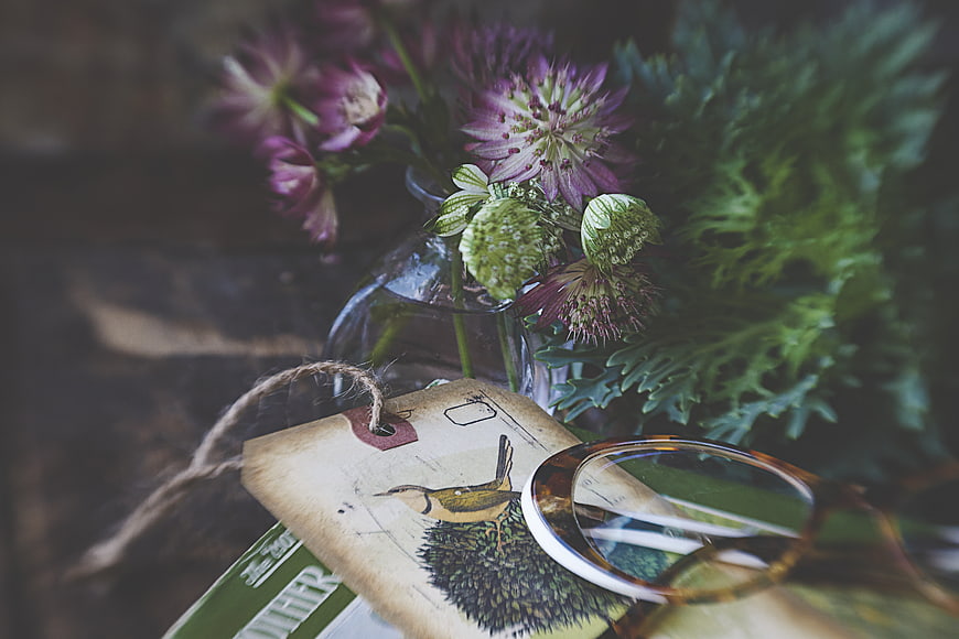 Vintage eyeglasses and flowers on rustic table