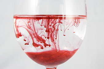Red Ink Diffusing in Water Inside a Clear Glass
