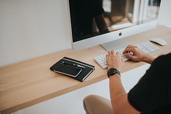 Man Typing on Computer at Minimalist Wooden Desk