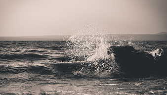 Dramatic Ocean Wave Splashing Against Dark Rock