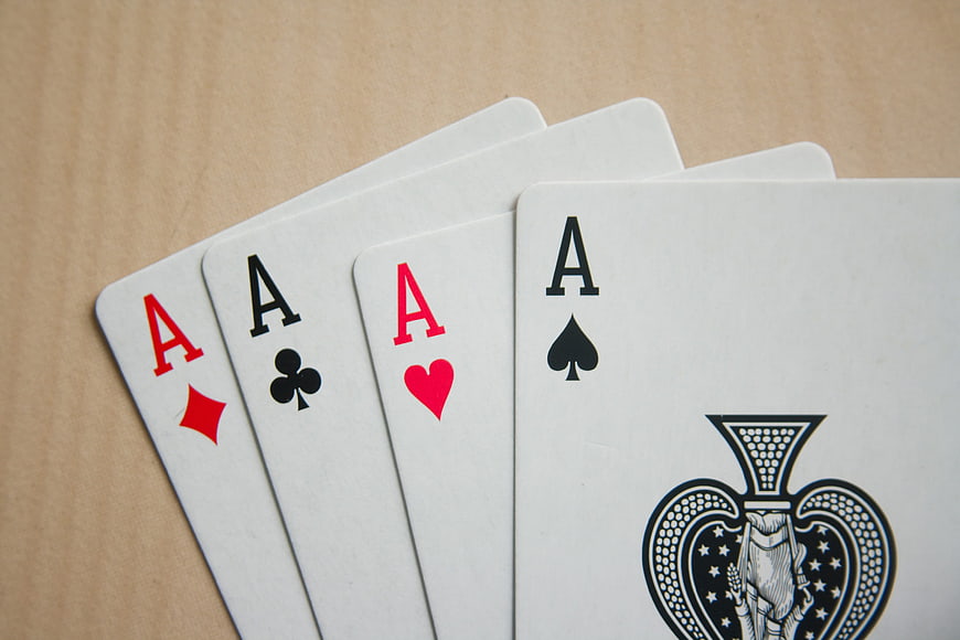 Four Aces of Spades, Hearts, Clubs, and Diamonds on Wood
