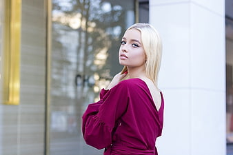 Blonde Woman In Burgundy Dress Standing In Urban Setting