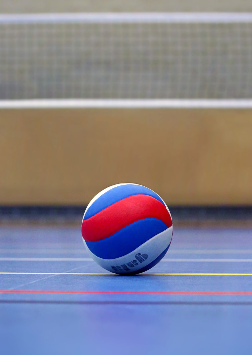 Red, White, and Blue Volleyball on Blue Court