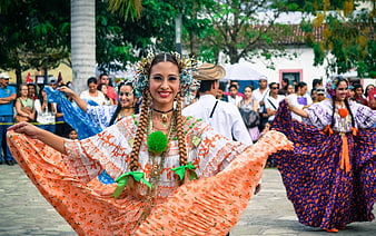 Traditional dancer in vibrant orange costume performing at cultural festival