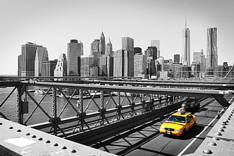 Yellow Taxi on Bridge with Black and White Manhattan Skyline
