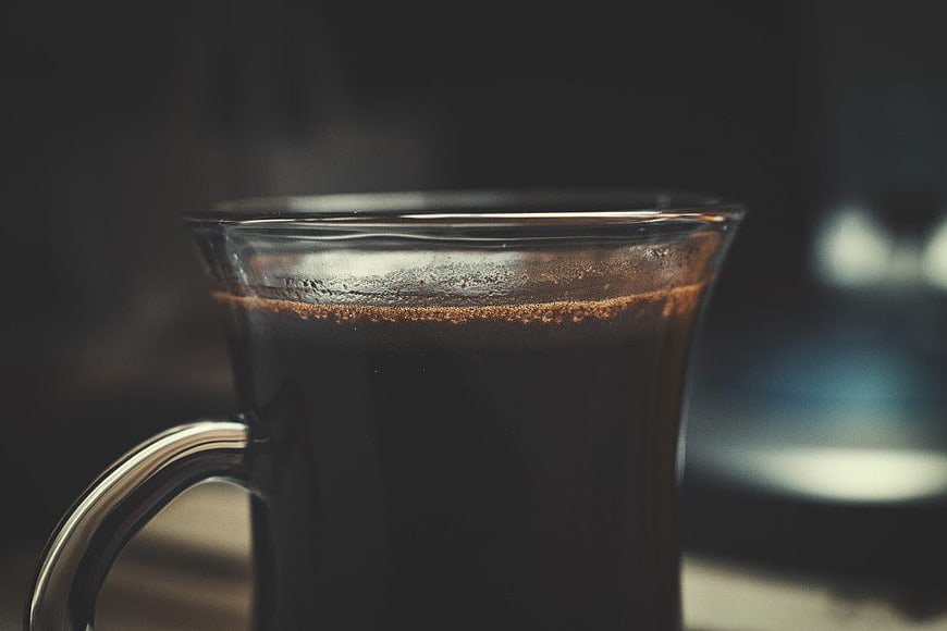 Close-up of hot black coffee in a glass mug