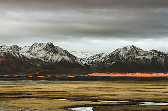 Dramatic Snow-Capped Mountains with Golden Sunset Light on Highland Valley