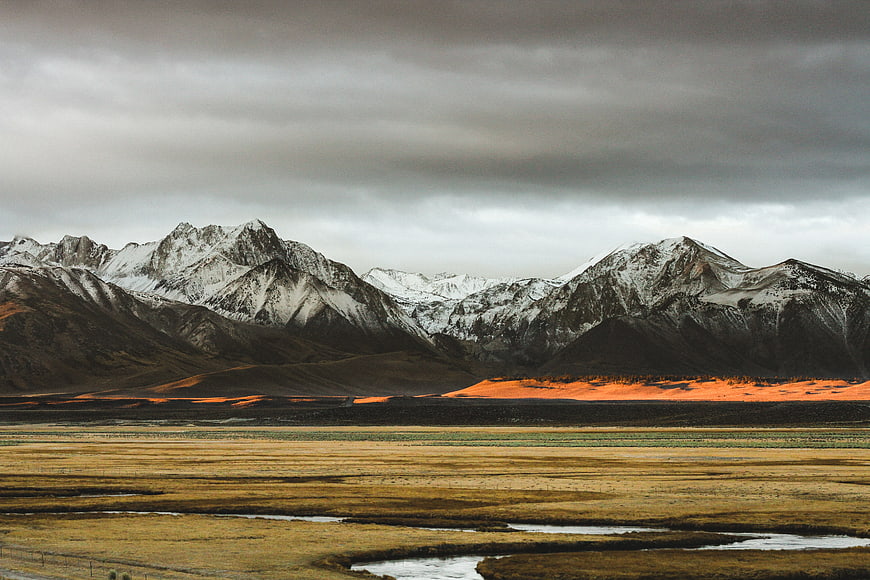 Dramatic Snow-Capped Mountains with Golden Sunset Light on Highland Valley